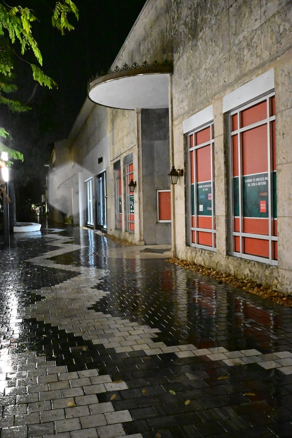 Red window panels above a patterned wet sidewalk