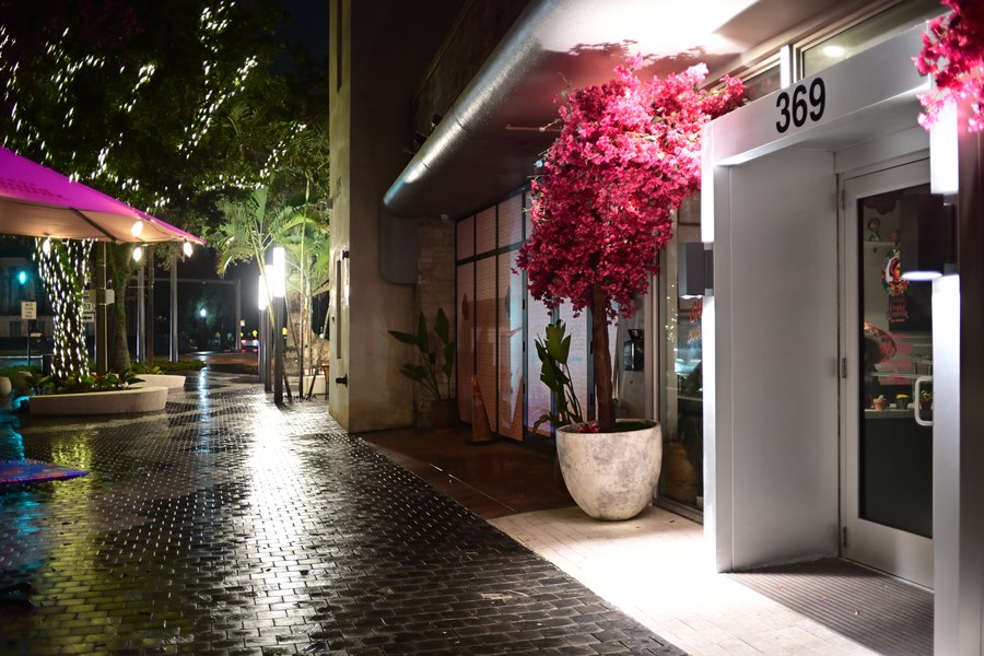 A flower-framed entrance beside the evening street