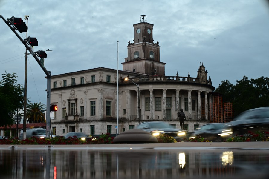 The clock tower at dusk with passing cars and reflections